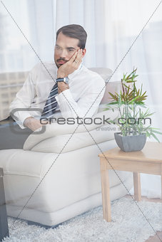 Businessman sitting on his couch seen through glass