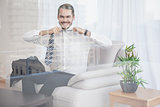 Happy businessman sitting on his couch seen through glass