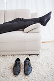 Businessman lying on couch legs only visible