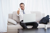 Businessman using laptop on his couch