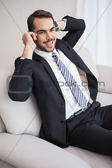 Businessman making a call on his couch