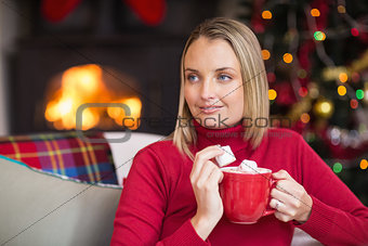 Blonde holding mug and eating marshmallow at christmas