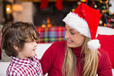 Festive mother and son smiling at each other