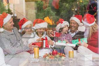 Multi generation family holding a lot of presents on sofa
