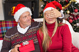 Man covering partner eyes and offering a gift to her