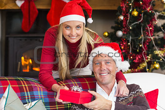 Happy woman offering husband a gift