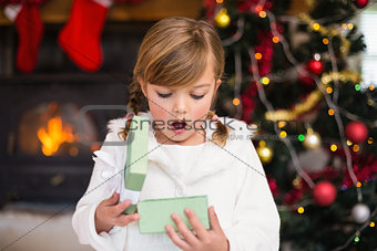 Shocked little girl opening a gift