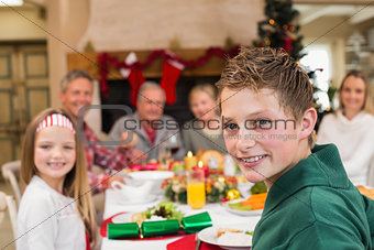 Portrait of a smiling son with his family behind him