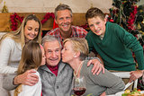 Multigeneration family with little girl kissing her grandfather