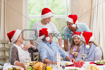 Happy extended family in santa hat speaking together