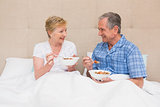 Senior couple having breakfast in bed