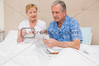 Senior couple having breakfast in bed