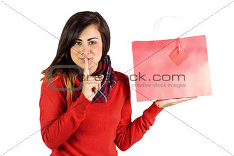 Brunette holding gift bag and keeping a secret