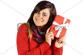 Excited brunette holding red gift