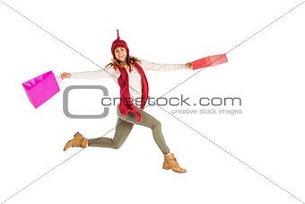 Happy brunette jumping with gifts bags