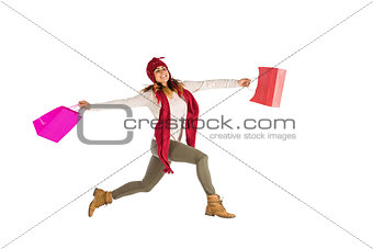 Smiling brunette jumping with gifts bags