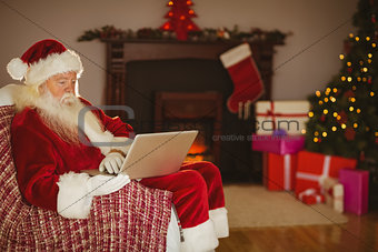 Santa using laptop on the couch at christmas