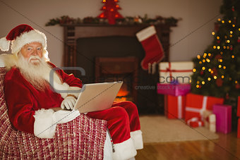 Santa using laptop on the couch at christmas