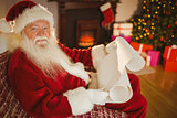 Smiling santa claus reading his list