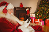 Santa claus listening music with his smartphone