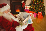 Father christmas reading newspaper on the couch