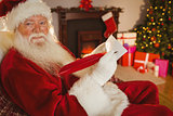 Smiling santa writing list with a quill