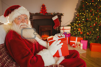 Smiling santa claus holding gift