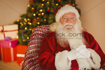 Smiling santa claus relaxing on the armchair