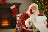 Concentrated santa writing his list on a scroll