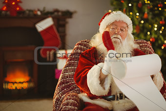 Concentrated santa writing his list on a scroll