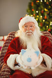 Father christmas offering piggy bank