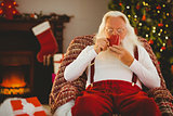 Smiling santa holding  cup of coffee