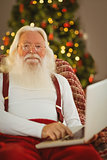Happy santa claus typing on laptop