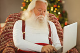 Father christmas typing on laptop