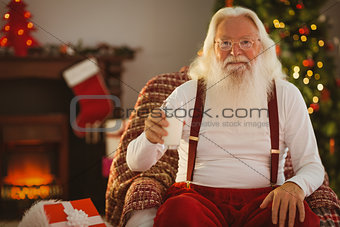 Smiling santa holding a glass of milk