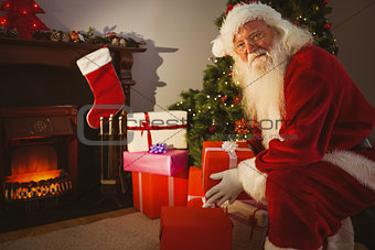 Smiling santa delivering gifts at christmas eve