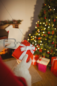 Father christmas holding paper and gift