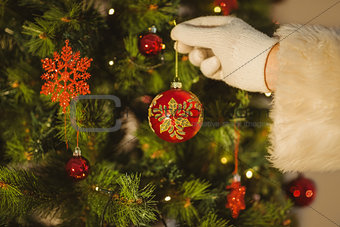 Hand of santa hanging a bauble