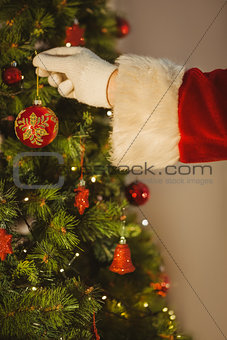 Hand of santa hanging a bauble