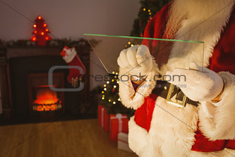 Mid section of santa writing list on glass