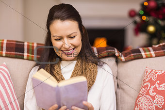 Pretty brunette reading book at christmas time