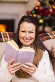 Smiling brunette reading on the couch