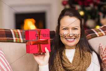 Pretty brunette woman showing christmas gift