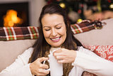 Happy brunette in winter clothes holding mug
