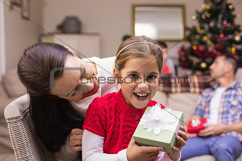 Happy mother and daughter holding a gift