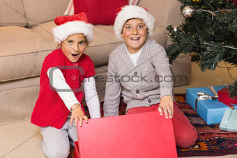 Astonished brother and sister opening a gift