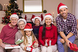 Multigeneration family wearing santa hats on the couch
