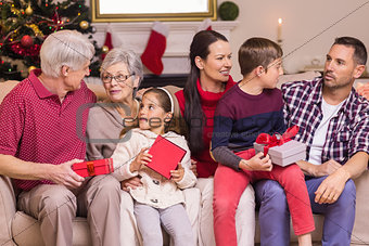 Multi generation family holding presents on sofa
