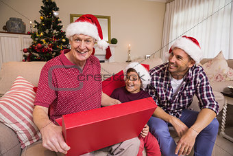 Smiling grandfather opening his gift