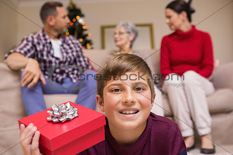 Smiling son with gift in front of his family